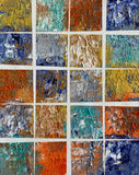 Abstract textured acrylic painting arranged in a grid of deep blue, turquoise, ochre, rust, burnt orange, warm brown, and silver-gray color fields.